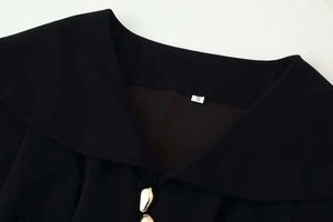 Detail of black off-shoulder neckline with elegant gold buttons and size label