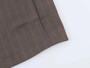 Detail shot of brown pinstripe fabric showing high-quality stitching and smooth texture