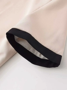 Détail du poignet tissé abricot clair avec bordure noire et doublure blanche lisse