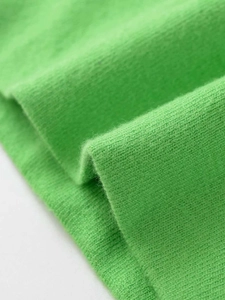 Macro-opname van levendige groene gebreide stof met zachte textuur en fijne details
