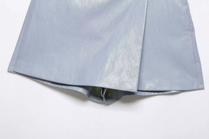 Détail du skort en cuir PU bleu clair avec texture grainée et design croisé chic