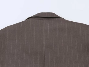Detail view of brown vertical striped blazer showing shoulder cut and fabric texture