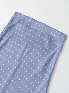 Detailed macro view of the light blue satin polka dot skirt fabric with silky texture