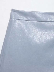 Détail d'une jupe en similicuir bleu clair montrant la taille haute et le grain lychee