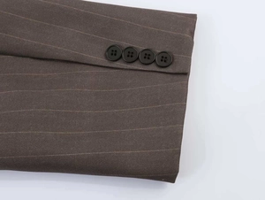 Detail of pinstriped suit sleeves with four black buttons on a taupe blazer cuff