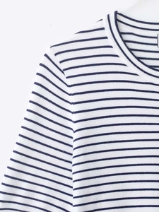 Detail of white knit top showing navy blue horizontal stripes and round neckline texture