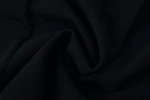 Detail shot of black chiffon fabric texture showing fine grain and soft draping folds
