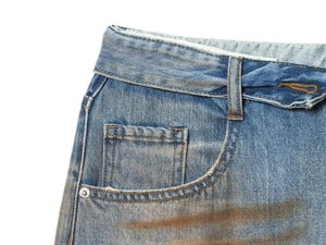 Detail of dark blue vintage denim jeans with classic orange stitching and rivet pocket