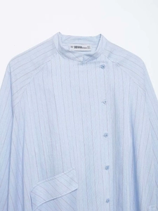 Detail of light blue striped shirt featuring a unique side button placket and mandarin collar