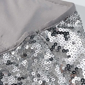 Macro detail of silver sequins and hidden zipper on a sparkling two-piece dress