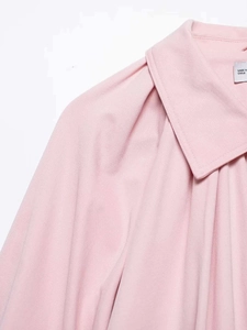 Detail view of pink button-down shirt showing collar texture and pleated puff sleeves