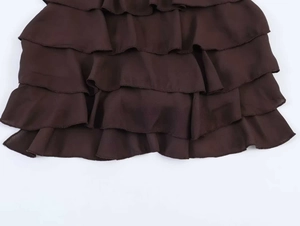 Detailansicht des mehrlagigen Rüschendesigns aus dunkelbraunem Chiffonstoff