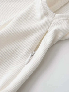 Detail of white ribbed knit fabric featuring a seamless concealed zipper closure design