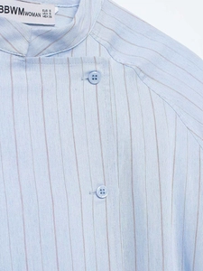 Detailed view of striped shirt collar featuring white brand label and neat stitching