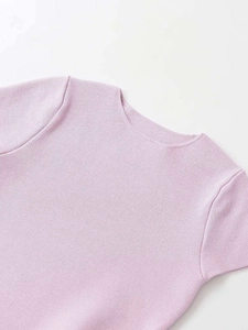 Dettaglio macro del girocollo e della trama a maglia fine di un top lavanda a maniche corte