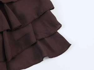 Detailansicht der dunkelbraunen Volants mit feiner Overlock-Naht am Saum des Stoffes