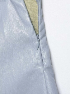 Vue détaillée de la fermeture éclair invisible sur une jupe en similicuir bleu clair
