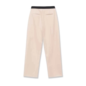 Détail du pantalon taille haute avec contraste noir à la taille et poches passepoilées