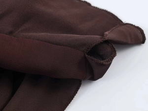Detaillierte Nahaufnahme des dunkelbraunen Stoffes mit präziser Overlock-Naht und elastischem Bund