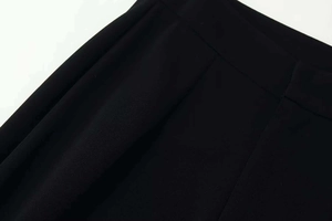 Detail shot of black woven fabric showing smooth waist seams and fine texture