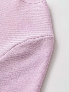 Dettaglio del tessuto in maglia lavanda con trama fine e cuciture sulle spalle