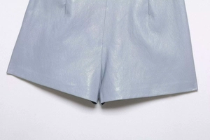 Détails du short en similicuir bleu clair montrant l'ourlet et la texture souple