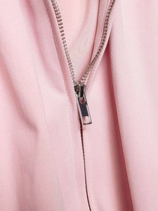 Close-up of the silver metal zipper and pink twill fabric on the fashion shirt