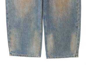Close-up of light blue distressed denim jeans with vintage wash and straight leg hem detail