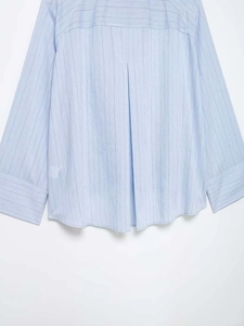 Detail of light blue striped shirt featuring a back yoke and inverted pleat design