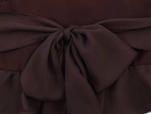 Detailaufnahme aus dunkelbraunem Chiffon mit dekorativer Schleife und feiner Kantenverarbeitung