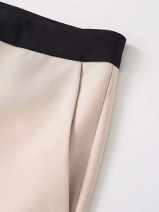 Détail du pantalon bicolore montrant les coutures de la taille et la structure de la poche
