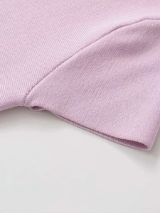 Dettaglio delle cuciture dei polsini e trama a maglia fine del top in maglia lavanda