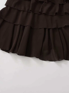 Detailed close-up of dark coffee-colored ruffled tiers on a chiffon midi skirt