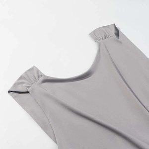 Detail of grey sleeveless top shoulder with subtle pleats and silky fabric texture