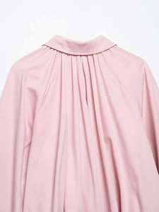 Close-up of pink shirt collar with detailed vertical pleats and soft texture fabric