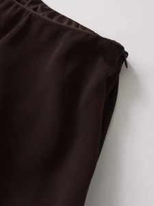 Detail of invisible side zipper on chocolate brown elastic waist midi skirt fabric