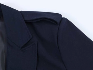 Detail view of navy blue blazer featuring notch lapels and epaulette shoulder decorations