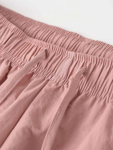 Detailed macro view of the pink quick-dry trousers showing elastic drawstring waist and texture