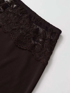 Detailed view of sophisticated floral lace hem on a dark brown elegant midi skirt