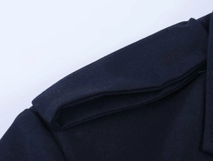 Close-up detail of navy double-breasted blazer showing shoulder epaulette stitching