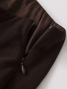 Detail of the high waist elastic band and invisible zipper on a brown midi skirt