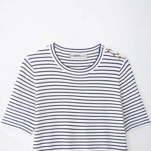 Short sleeve white and blue striped knit sweater with decorative gold buttons on shoulder