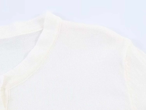 Detailed close-up showing the fine knit texture and neckline of the white slim sweater