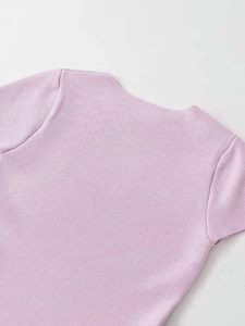 Dettaglio del top in maglia lilla che mostra la trama fine e lo scollo tondo rifinito