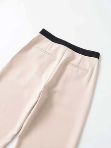 Détail du pantalon droit avec taille contrastée et poches arrière à finitions soignées