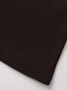 Detailed macro view of the double-stitched hem and knit fabric texture of the black skirt
