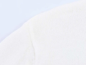 Macro shot of high-density white knitted fabric showing detailed fiber texture and stitching