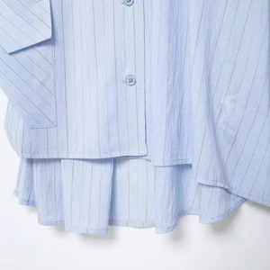 Women's light blue striped casual shirt with layered ruffle hem and button details