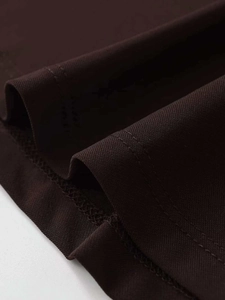 Detailed macro view of the dark brown knitted hem showing neat double-needle stitching