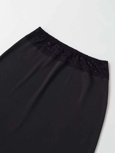 Detailed close-up of the black elastic lace waistband on a minimalist slim skirt